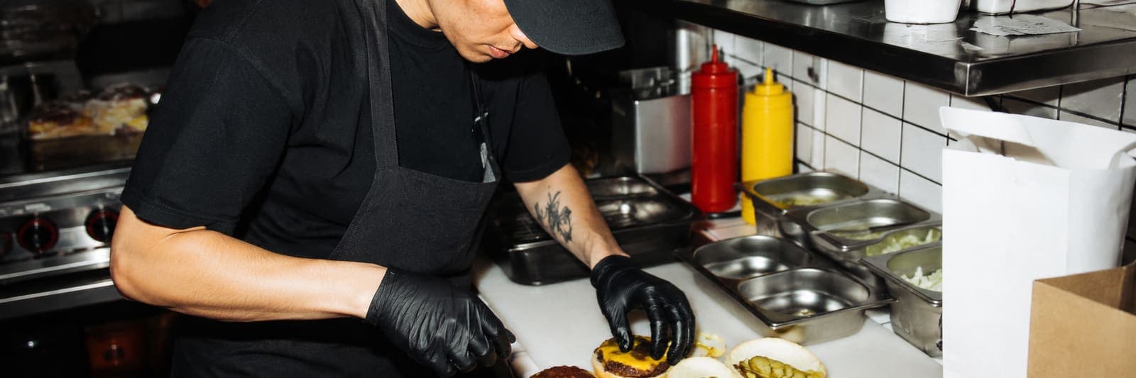 Chef assembling burgers in a delivery kitchen